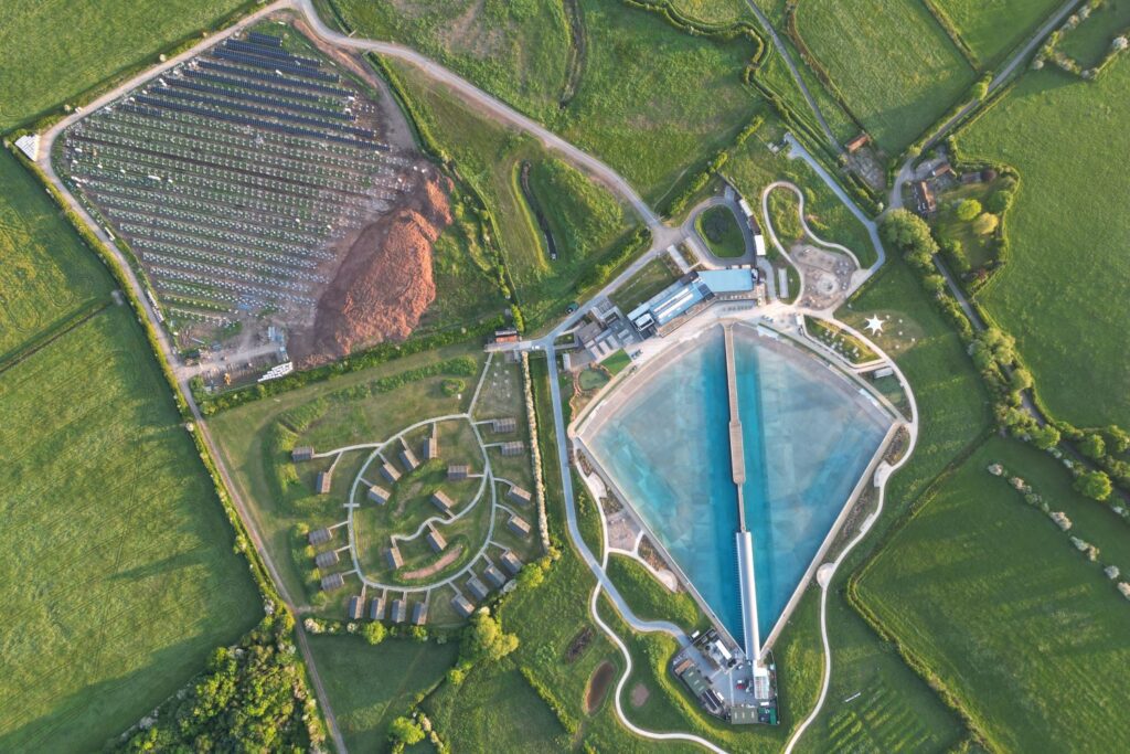 Ariel view of a surfing lake and solar farm.